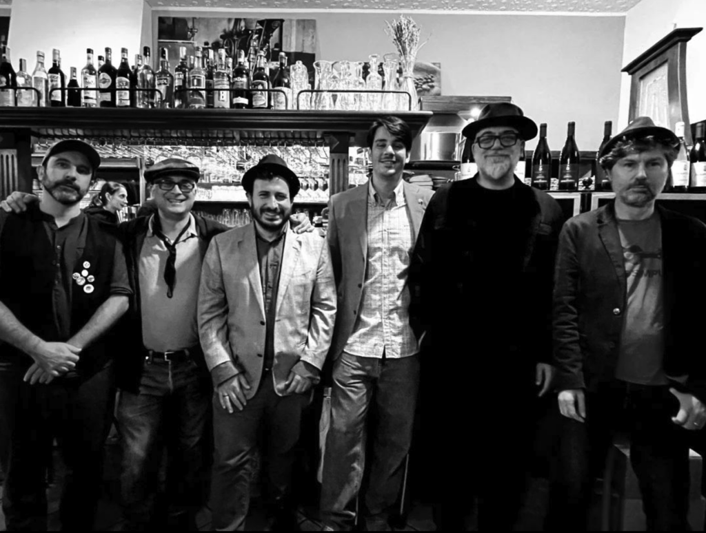 Foto di gruppo in bianco e nero davanti al bancone del bar tabacchi Varisco